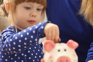 Foto: Kind mit Sparschwein